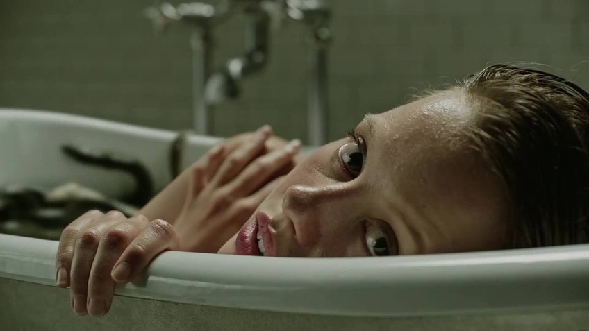 Hannah (Mia Goth) lounges in a tub full of eels in a scene from "A Cure for Wellness." Courtesy of 20th Century Fox.