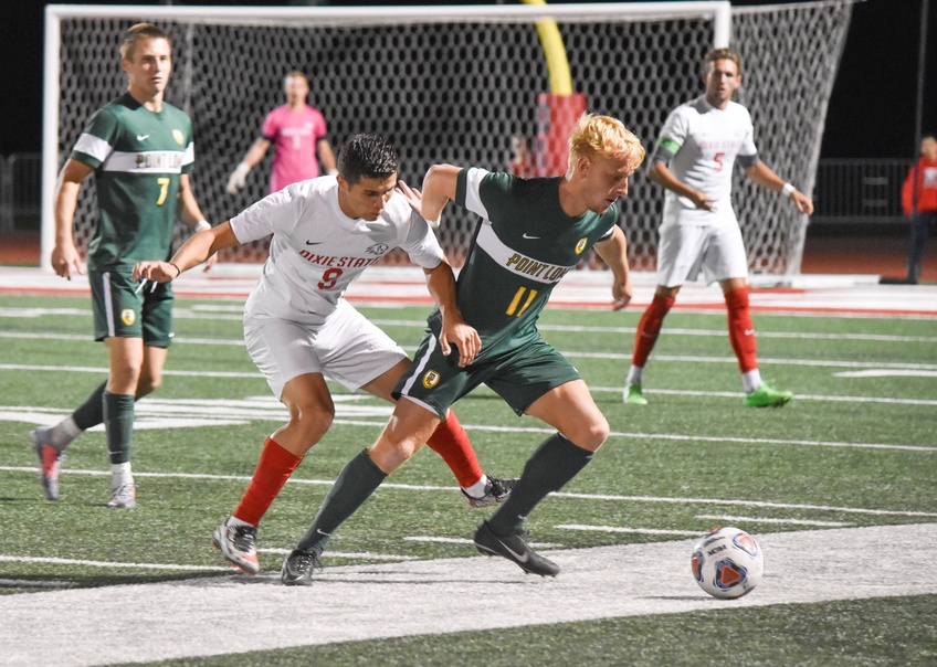 Sophomore forward Moises Medina, a general studies major from Mesquite, Nevada, charges after a Point Loma Nazarene University player to gain possession of the ball Saturday. Photo by Kylea Custer.